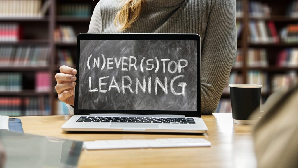 Picture of open laptop with Never Stop Learning on the screen